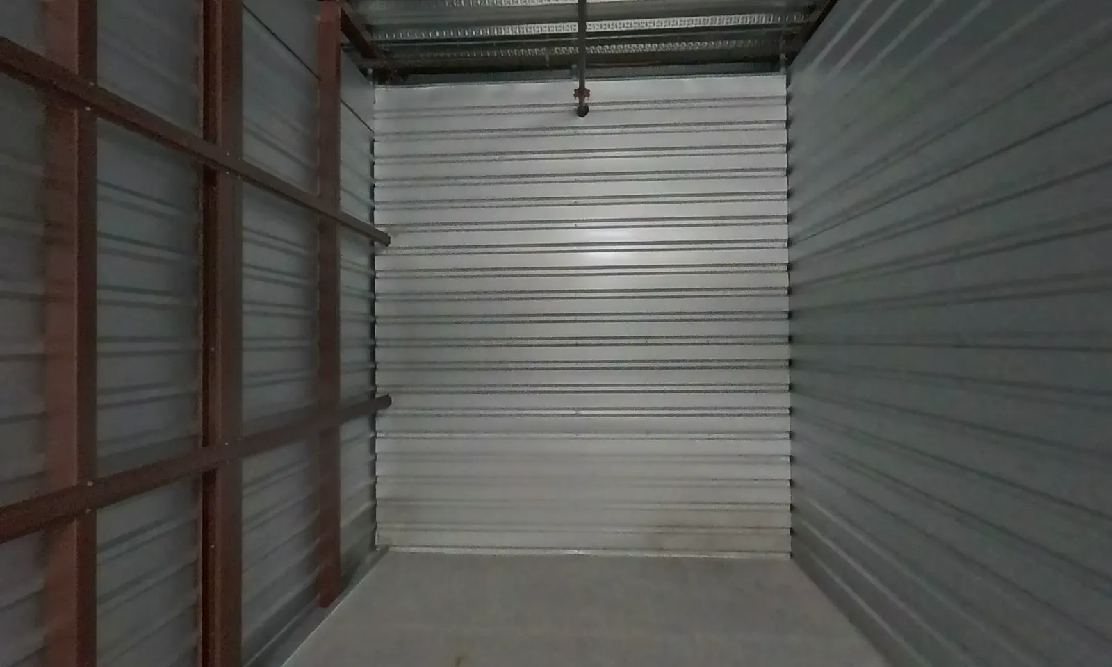 Empty 10x25 storage unit interior with a roll-up door at Sunny Storage